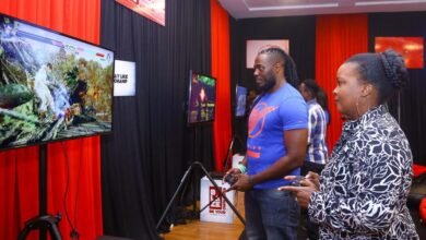Safaricom Senior Manager Youth Segment Angela Githuthu (Left), Battle it out in a combat play station game with Blaze mentor and professional gamer Brian Diang’a during the Safaricom Blaze e-sports tournament launch.