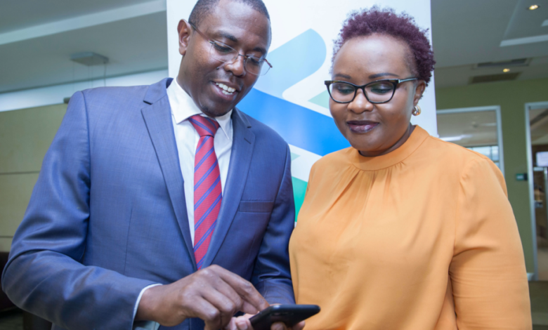 Standard Chartered Head of Wealth Management Kenya and East Africa Paul Njoki (left), takes the bank's Head of Retail Banking Kenya Edith Chumba through the T bills and Bonds trading process during the launch