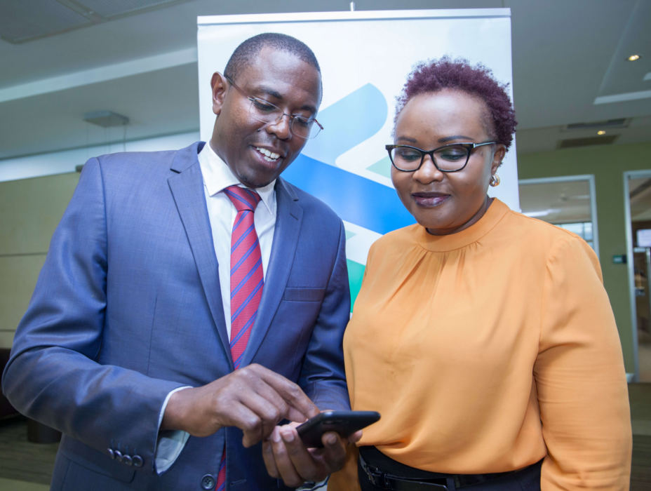 Standard Chartered Head of Wealth Management Kenya and East Africa Paul Njoki (left), takes the bank's Head of Retail Banking Kenya Edith Chumba through the T bills and Bonds trading process during the launch
