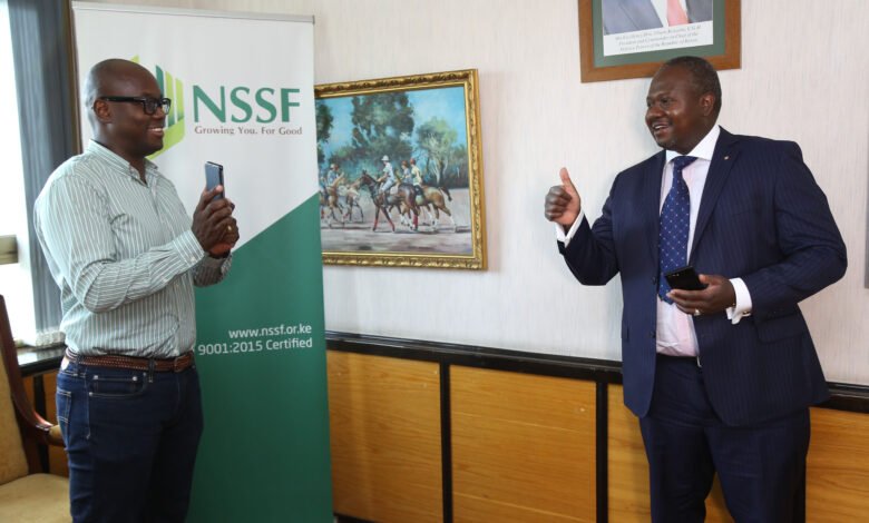 CEO NSSF Dr. Antony Omerikwa(right) is shown how to purchase scheme installments service charge through M-PESA by Austin Ouko General Manager NSSF (left), during the announcement of a partnership with Safaricom.