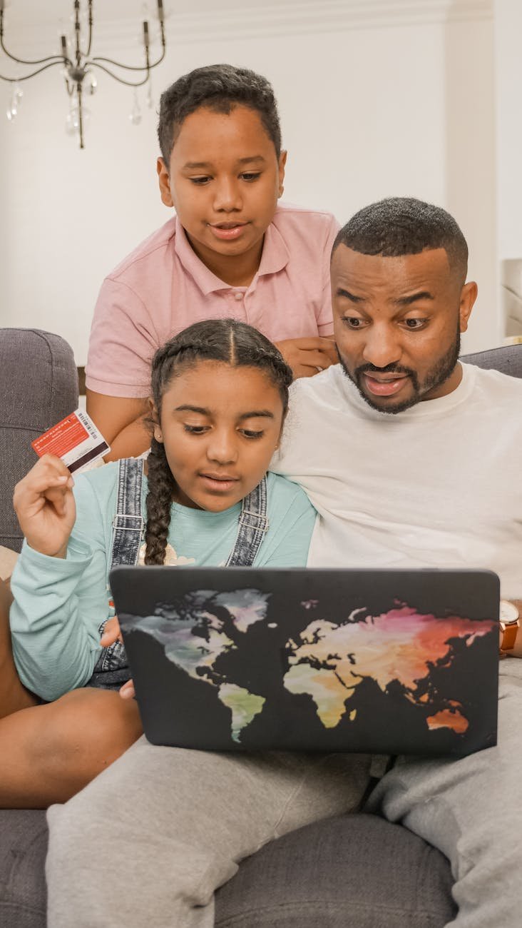 Safer Internet Day 2026 shifts from basic safety to AI readiness, emphasizing critical thinking, media literacy, and collective digital responsibility. photograph of a family looking at a laptop screen