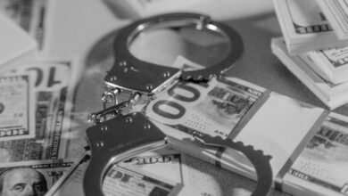 silver handcuffs on top of bundled paper money