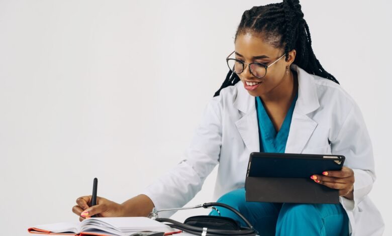 doctor using a tablet and taking notes in a notebook